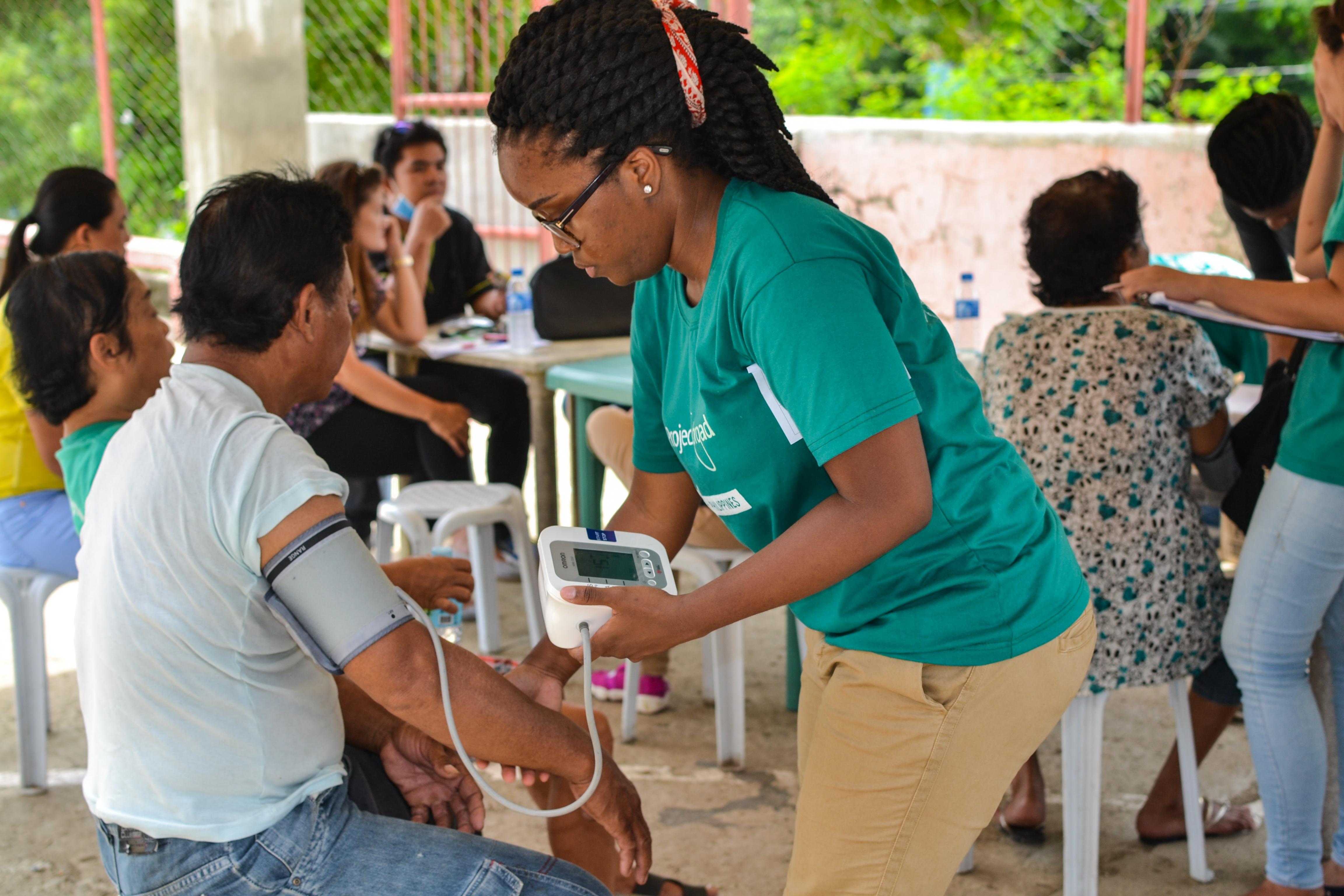 A Projects Abroad intern measures the blood pressure of a patient during her Public Health work experience in the Philippines. During an outreach, a student takes the blood pressure of a patient during her Public Health internship in the Philippines.